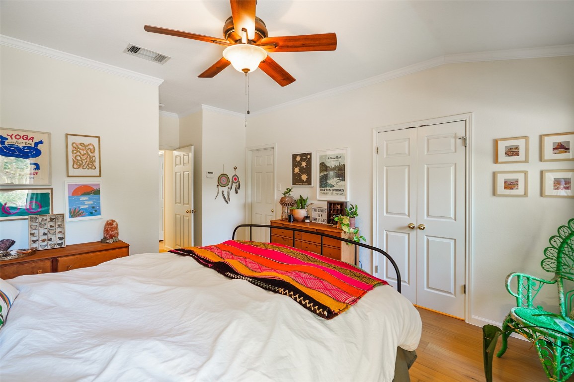 1422 Wheatfall Lane Austin, TX 78748 - Photo 20 of 29 a bedroom with a bed a dresser and a chandelier