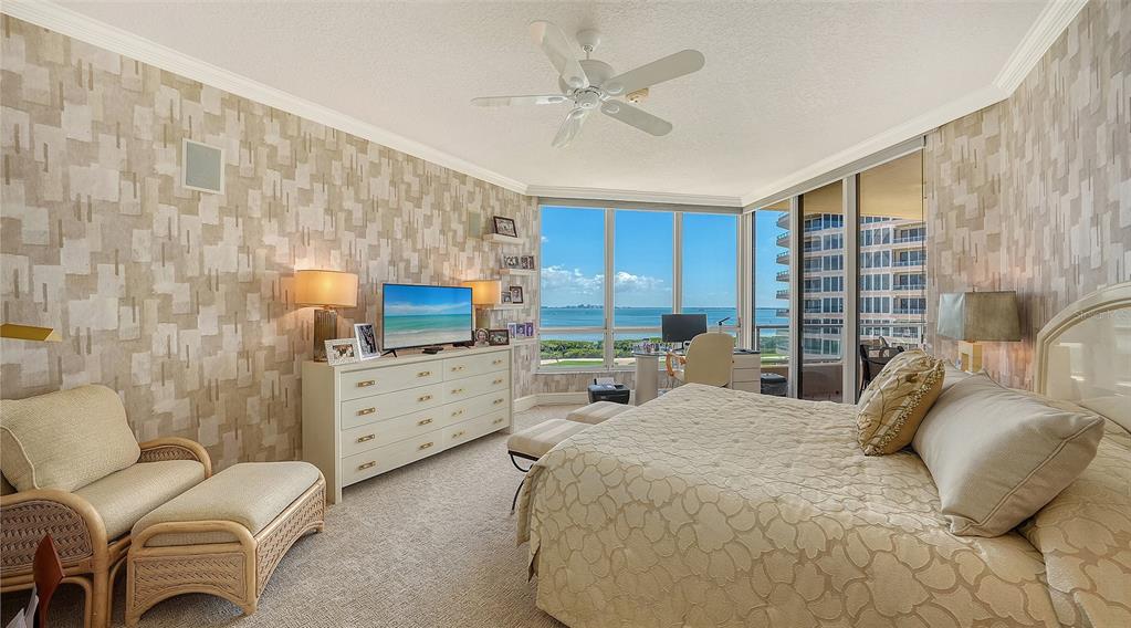 3060 Grand Bay Boulevard, Unit 155 Longboat Key, FL 34228 - Photo 19 of 67 a bedroom with a bed a couch and a flat screen tv