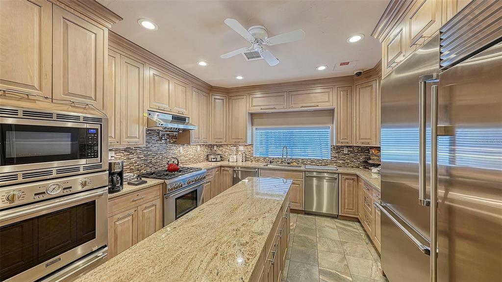 3060 Grand Bay Boulevard, Unit 155 Longboat Key, FL 34228 - Photo 47 of 67 a kitchen with stainless steel appliances granite countertop a stove top oven a sink dishwasher a refrigerator and a oven with wooden floor