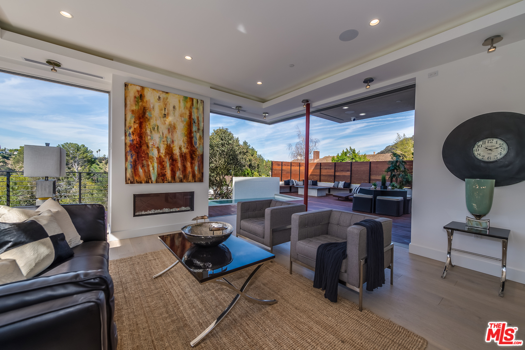 3431 Coy Drive Sherman Oaks, CA 91423 - Photo 11 of 54 a living room with fireplace furniture and a large window
