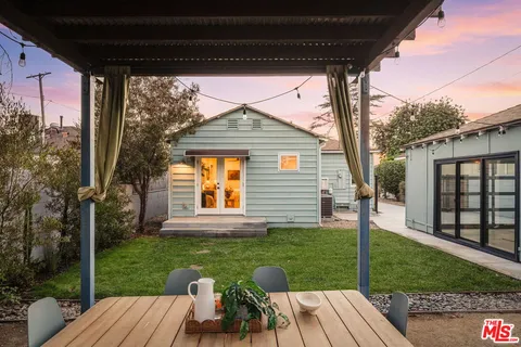 a view of backyard with table and chairs and wooden fence