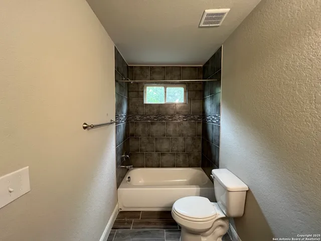 a bathroom with a toilet and a bath tub