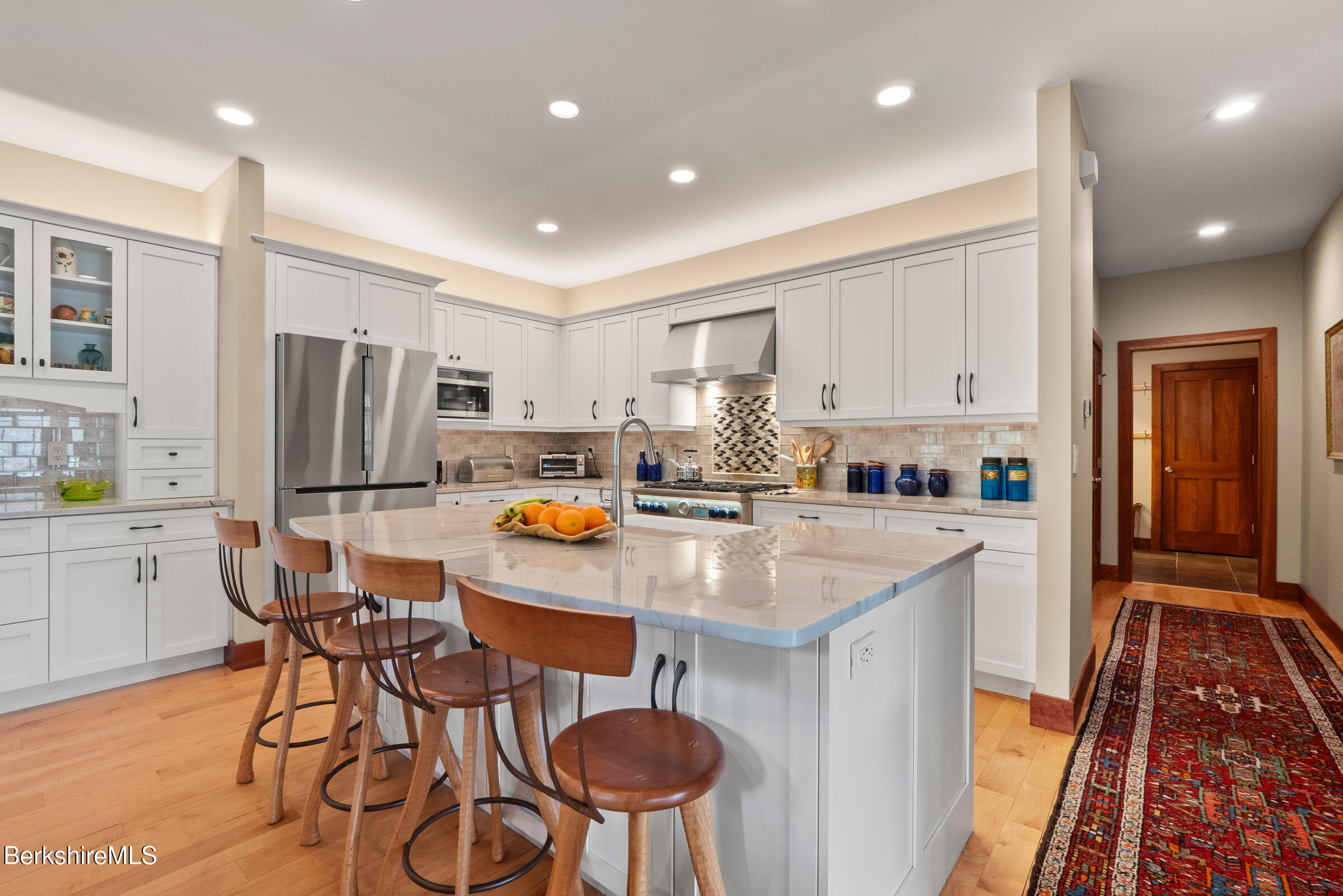 62 Stockbridge Terrace Lee, MA 01238 - Photo 14 of 49 a kitchen with stainless steel appliances a dining table chairs refrigerator and sink
