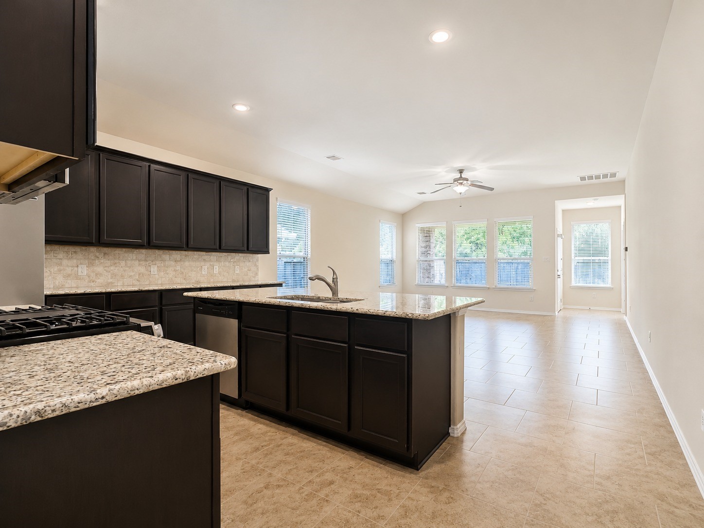 24315 Ravenna Landing Loop Spring, TX 77389 - Photo 12 of 37 a kitchen with granite countertop a stove a sink and a microwave