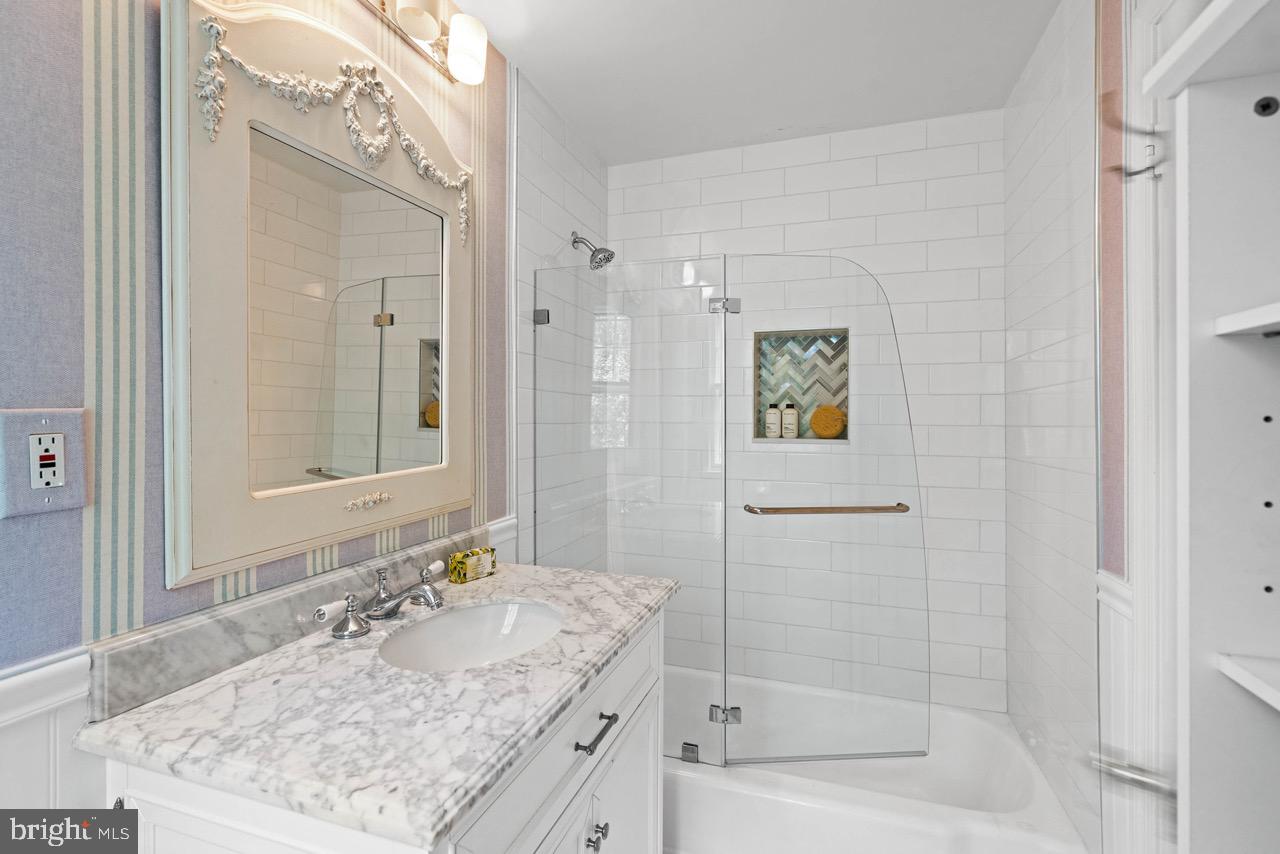 8 Farmington Court Chevy Chase, MD 20815 - Photo 27 of 34 a bathroom with a granite countertop sink a mirror a bathtub and shower