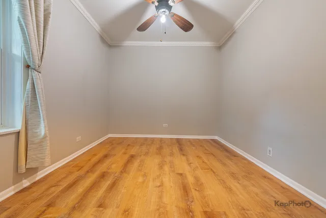 a view of a room with wooden floor and a ceiling fan