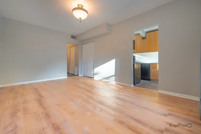 a view of empty room with wooden floor