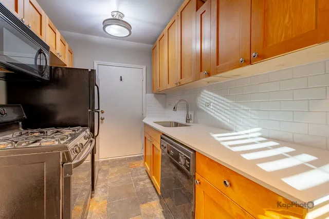 a kitchen with stainless steel appliances a stove a sink and a refrigerator