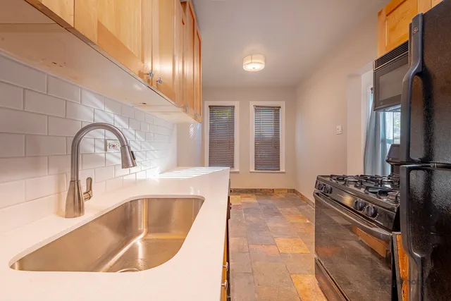 a kitchen with granite countertop a sink stainless steel appliances and cabinets