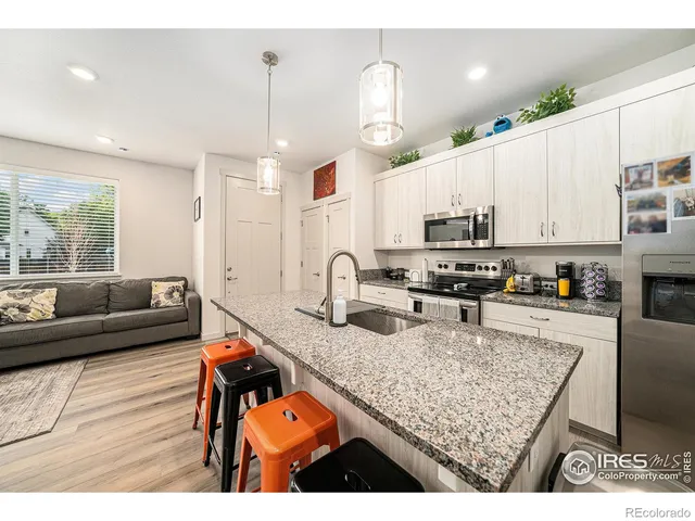 a kitchen with sink refrigerator and microwave