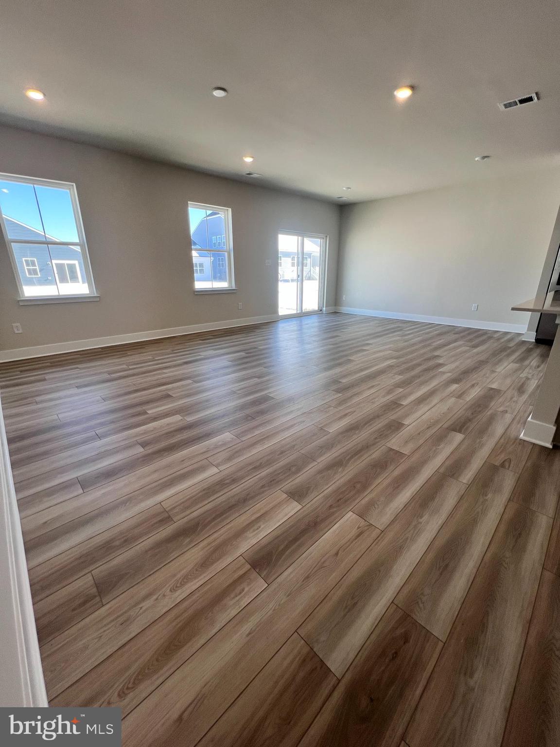 24718 Ridgeville Way Millsboro, DE 19966 - Photo 4 of 16 an empty room with wooden floor and windows