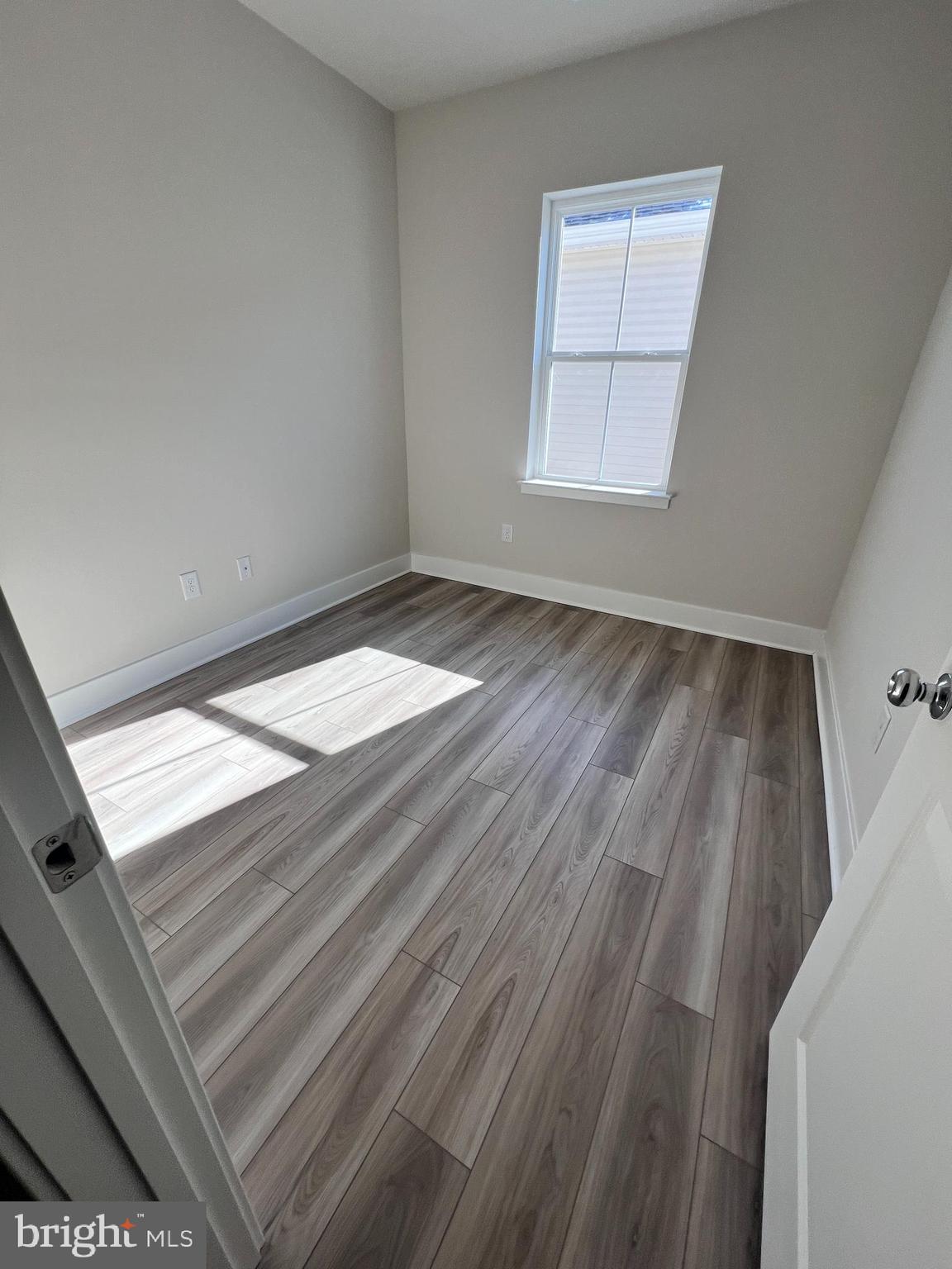 24718 Ridgeville Way Millsboro, DE 19966 - Photo 7 of 16 an empty room with wooden floor and windows