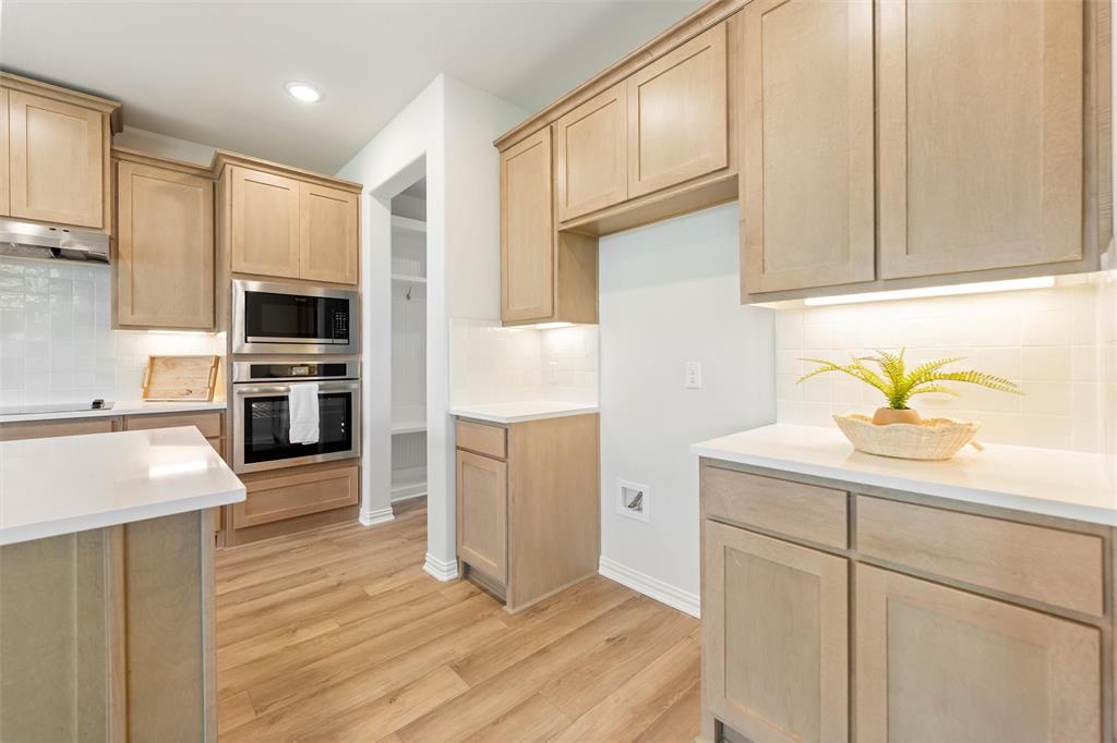 157 Brandywine Trail Rhome, TX 76078 - Photo 13 of 33 Kitchen featuring light brown cabinets, appliances with stainless steel finishes, tasteful backsplash, light wood-style floors, and recessed lighting