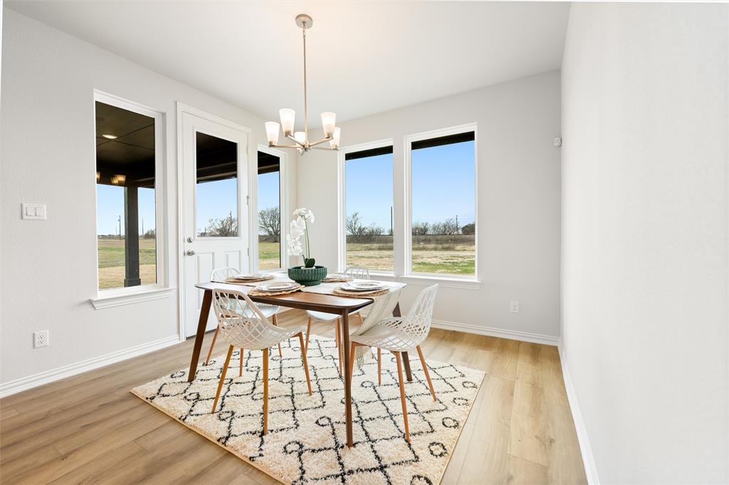157 Brandywine Trail Rhome, TX 76078 - Photo 17 of 33 Dining area featuring light wood-type flooring and a chandelier