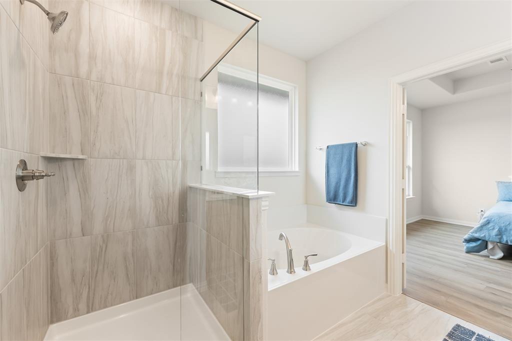 157 Brandywine Trail Rhome, TX 76078 - Photo 25 of 33 Ensuite bathroom with a garden tub, a tile shower, and wood finished floors