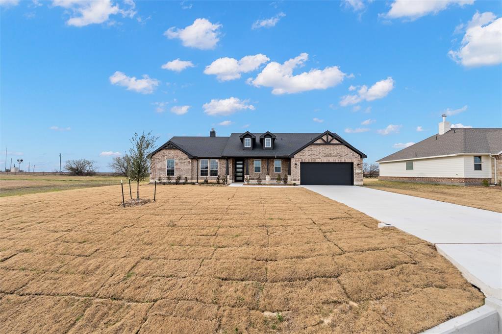 157 Brandywine Trail Rhome, TX 76078 - Photo 3 of 33 View of front facade featuring driveway, a front lawn, an attached garage, and brick siding