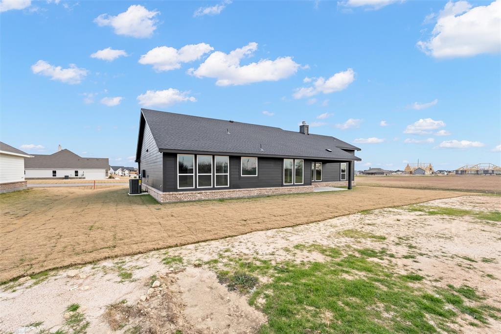 157 Brandywine Trail Rhome, TX 76078 - Photo 31 of 33 Back of house with a patio area, a chimney, and a yard