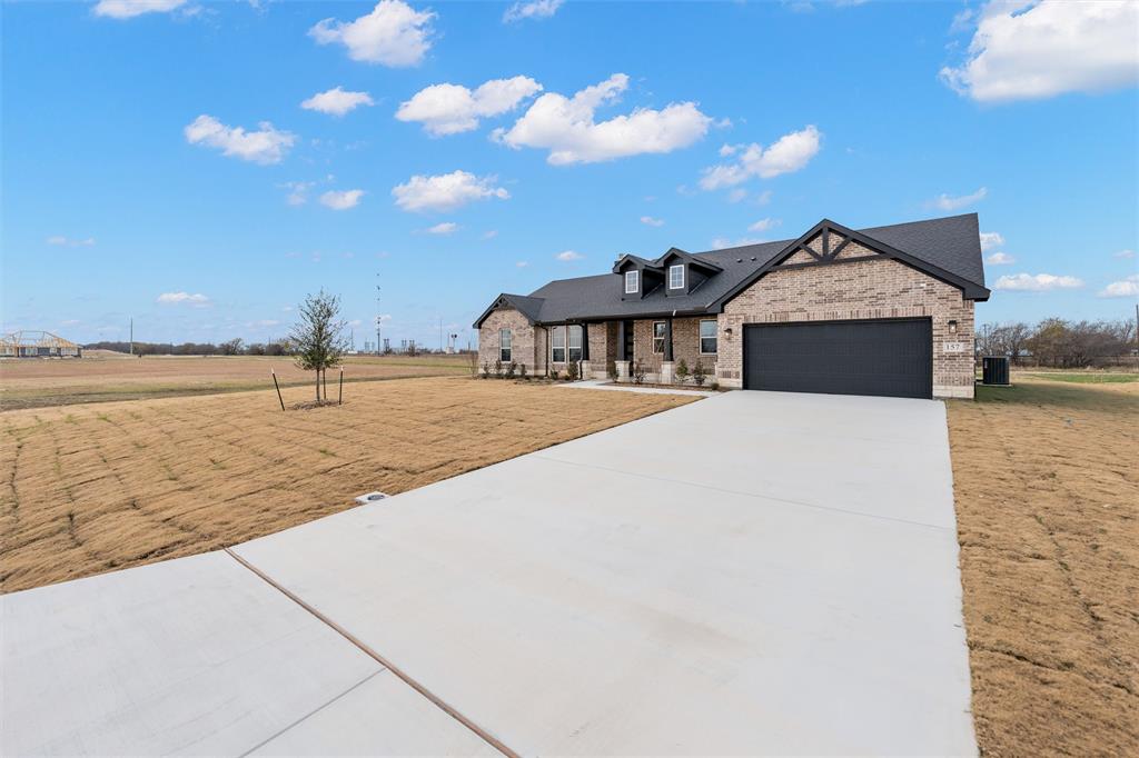 157 Brandywine Trail Rhome, TX 76078 - Photo 4 of 33 View of front of house with a front lawn, concrete driveway, brick siding, and a garage