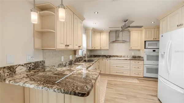 a kitchen with white cabinets and refrigerator
