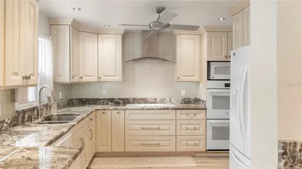 a kitchen with stainless steel appliances granite countertop a sink and cabinets
