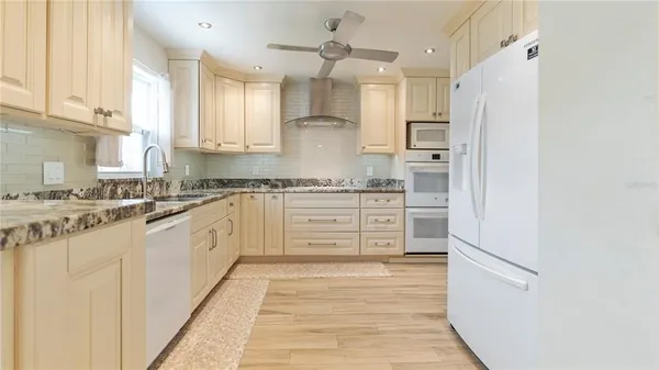 a kitchen with stainless steel appliances granite countertop a refrigerator and a stove top oven