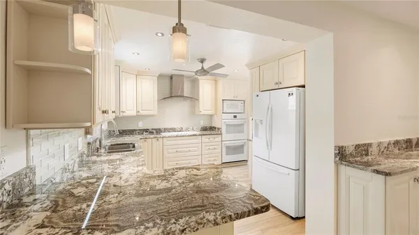 a kitchen with white cabinets and white appliances