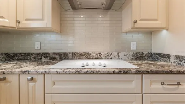 a bathroom with a granite countertop sink and a white cabinets