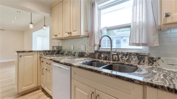 a kitchen with granite countertop a sink and a window