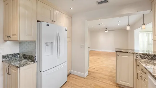 a bathroom with a granite countertop sink and a refrigerator