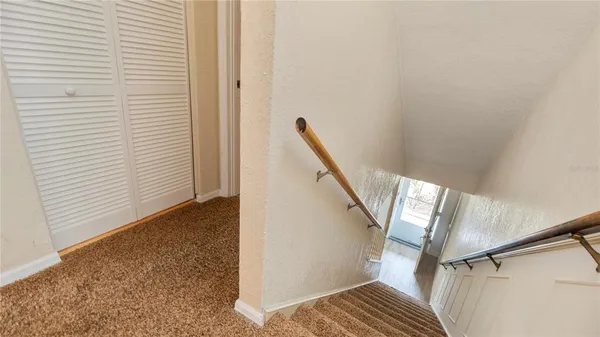 a view of staircase with wooden floor and white walls