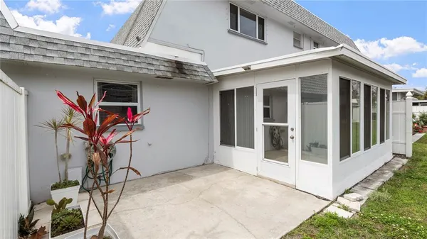 a view of a white house with a small yard and floor to ceiling window