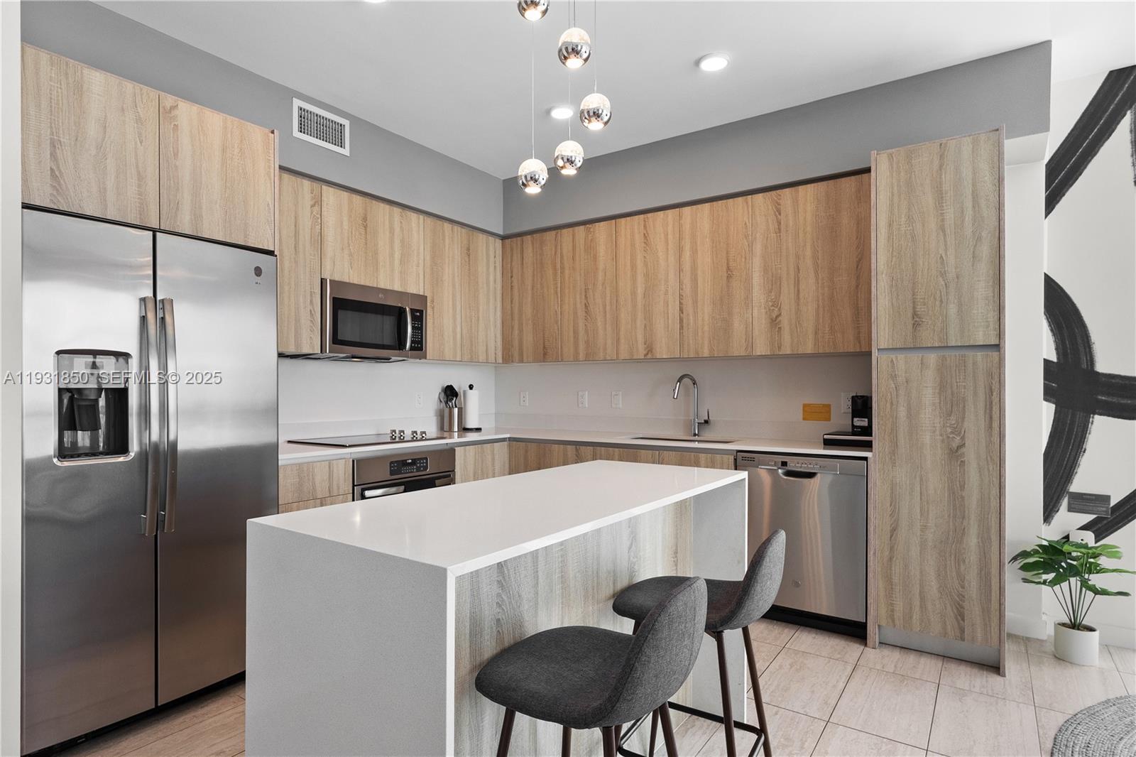 3900 Biscayne Boulevard, Unit S802 Miami, FL 33137 - Photo 4 of 29 a kitchen with stainless steel appliances a stove refrigerator sink and microwave