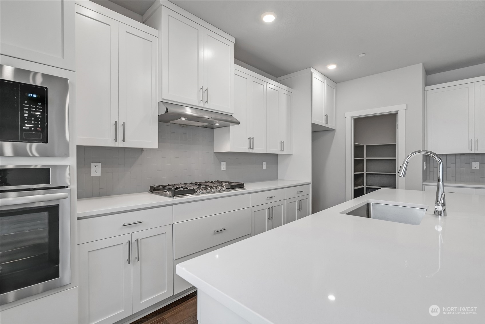 709 South 29th Court Ridgefield, WA 98642 - Photo 10 of 21 a kitchen with kitchen island white cabinets and white appliances