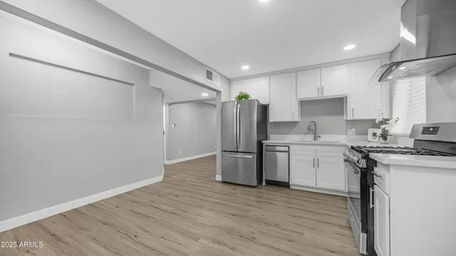 a kitchen with stainless steel appliances granite countertop a stove a refrigerator and a sink