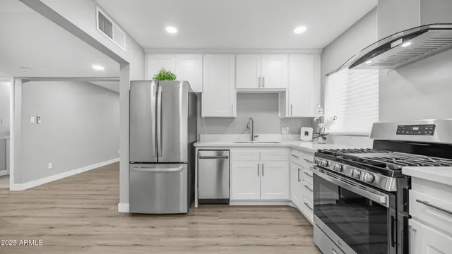 a kitchen with granite countertop a sink stainless steel appliances and cabinets