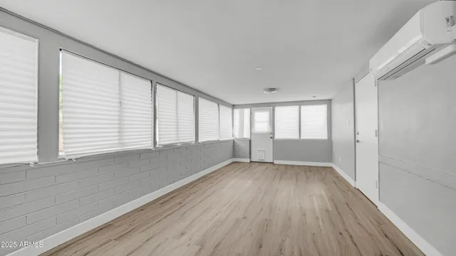 a view of empty room with wooden floor and fireplace