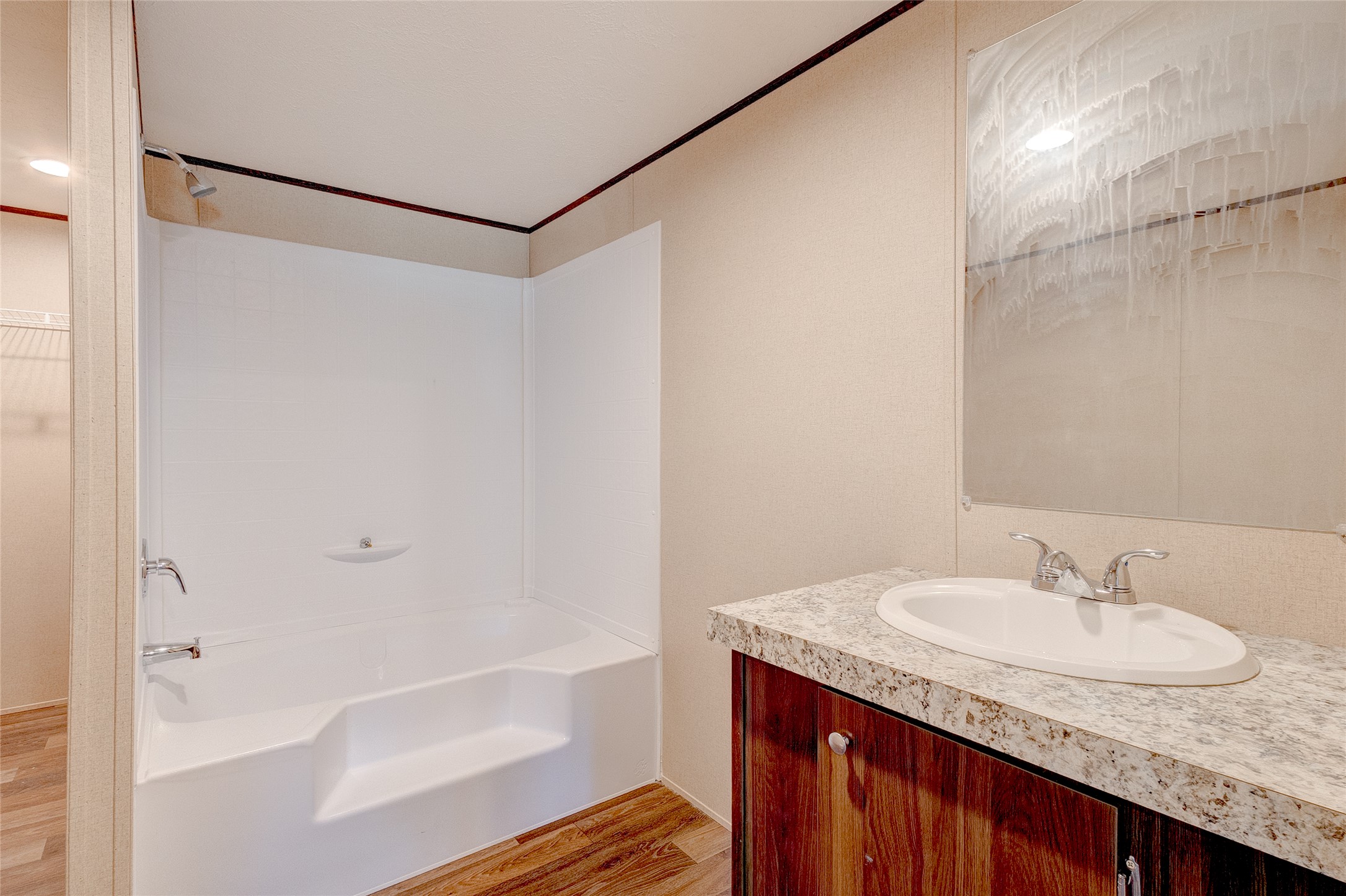 107 Los Cueva Road Elgin, TX 78621 - Photo 25 of 31 Bathroom featuring light wood finished floors, washtub / shower combination, vanity, ornamental molding, and a spacious closet
