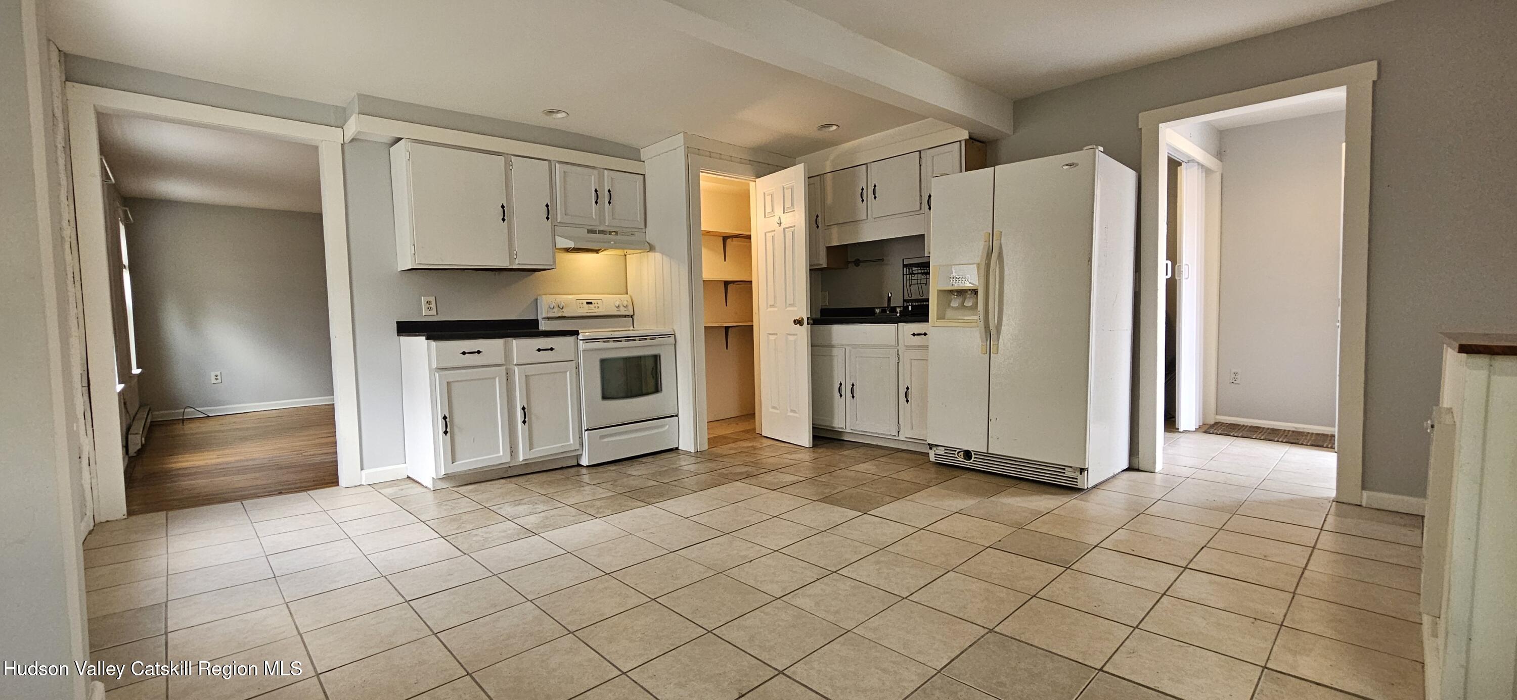22 Spring Street Chatham, NY 12037 - Photo 23 of 61 a kitchen with white cabinets a refrigerator and a stove