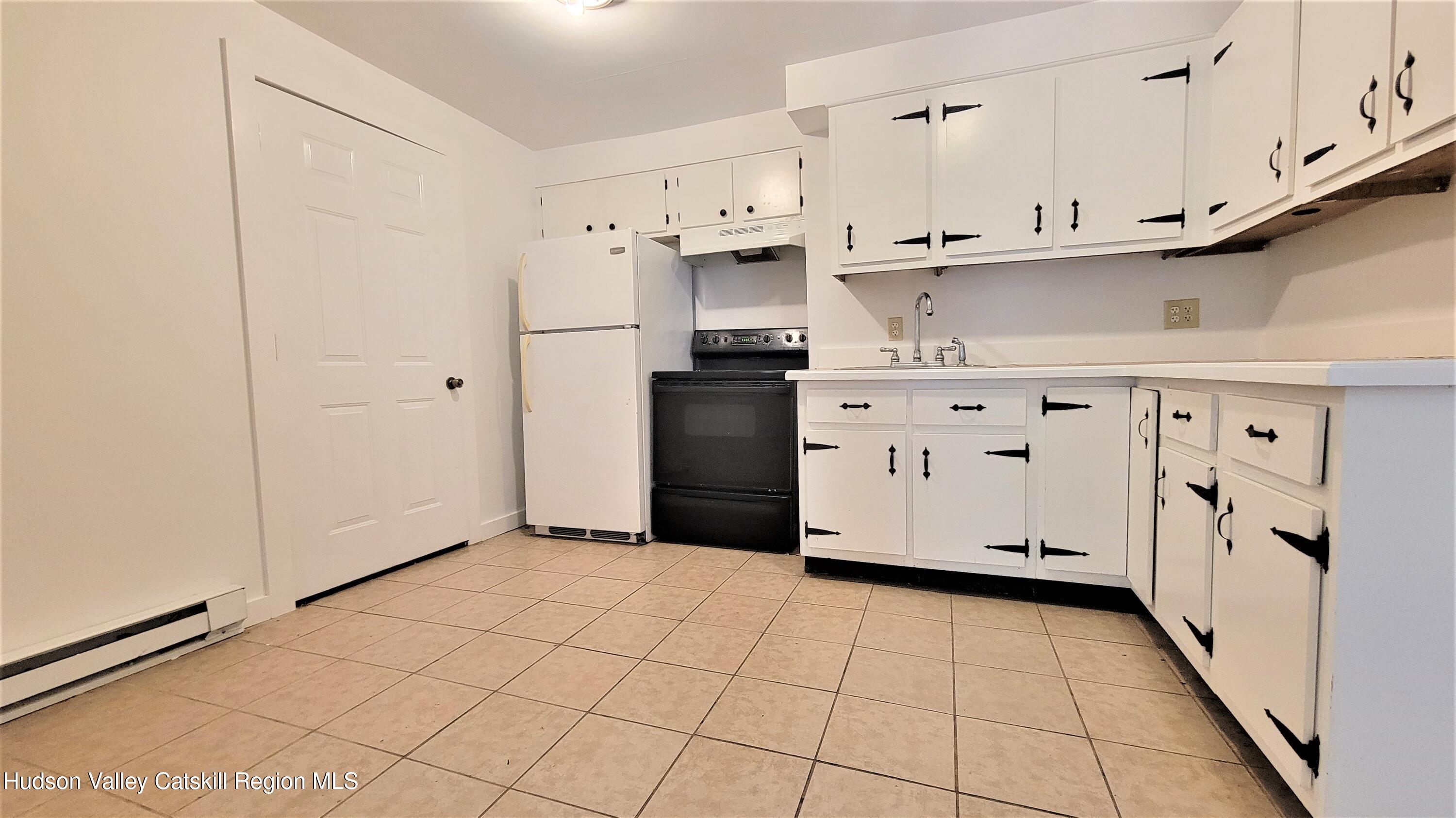 22 Spring Street Chatham, NY 12037 - Photo 27 of 61 a kitchen with white cabinets and white appliances