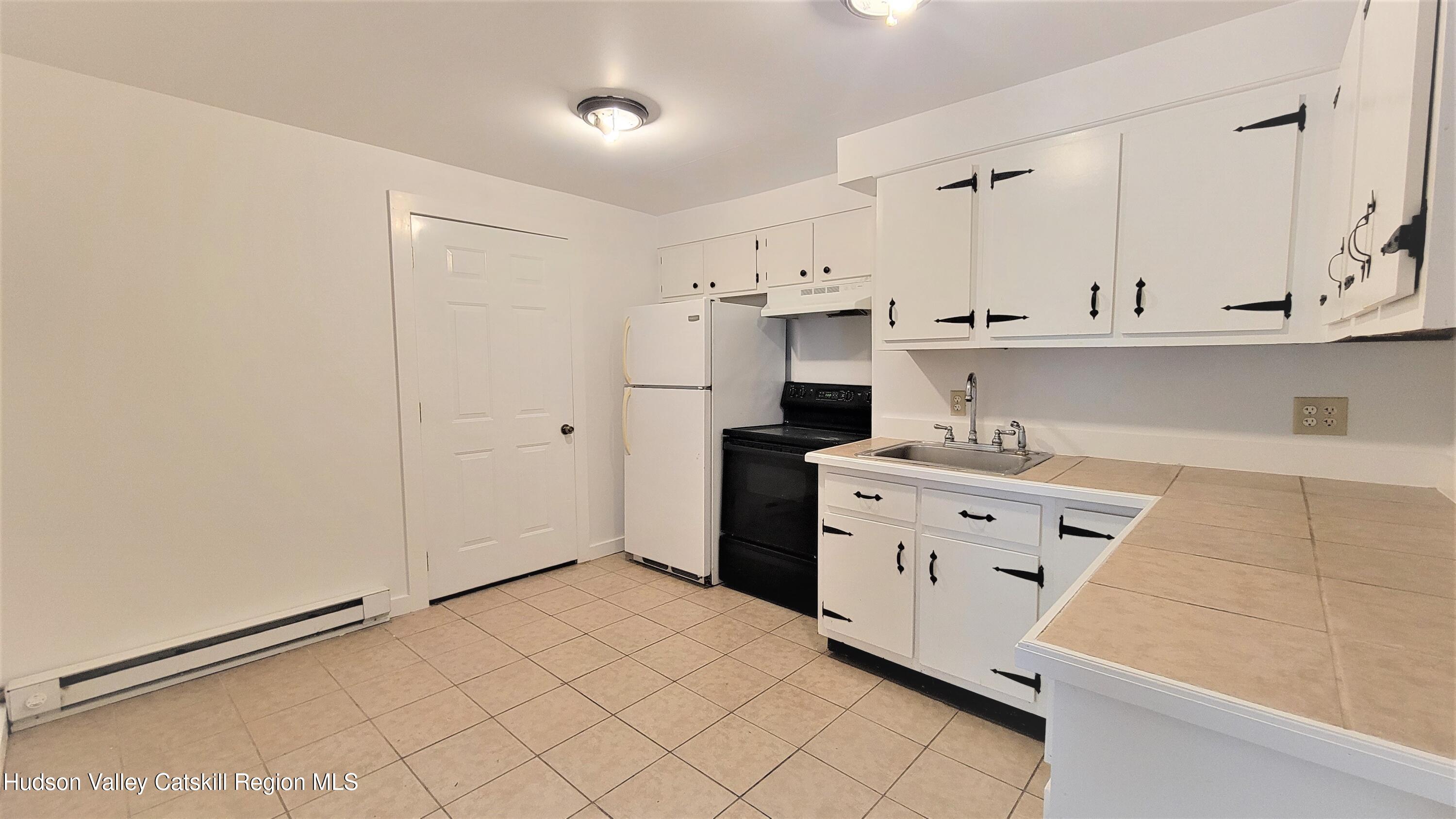 22 Spring Street Chatham, NY 12037 - Photo 28 of 61 a kitchen with granite countertop white cabinets and refrigerator