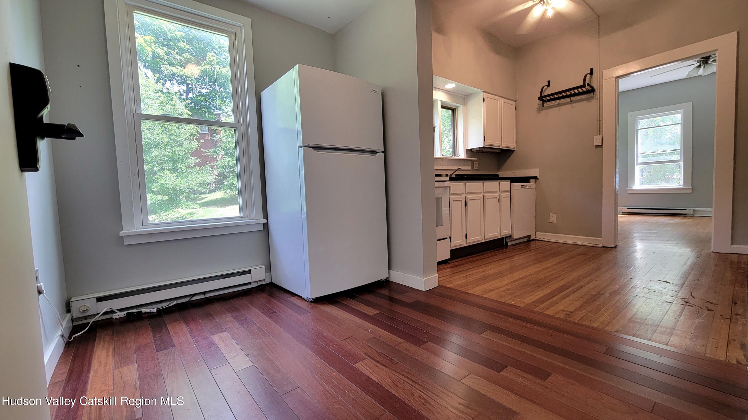 22 Spring Street Chatham, NY 12037 - Photo 47 of 61 a kitchen with kitchen island wooden floors appliances and white cabinets