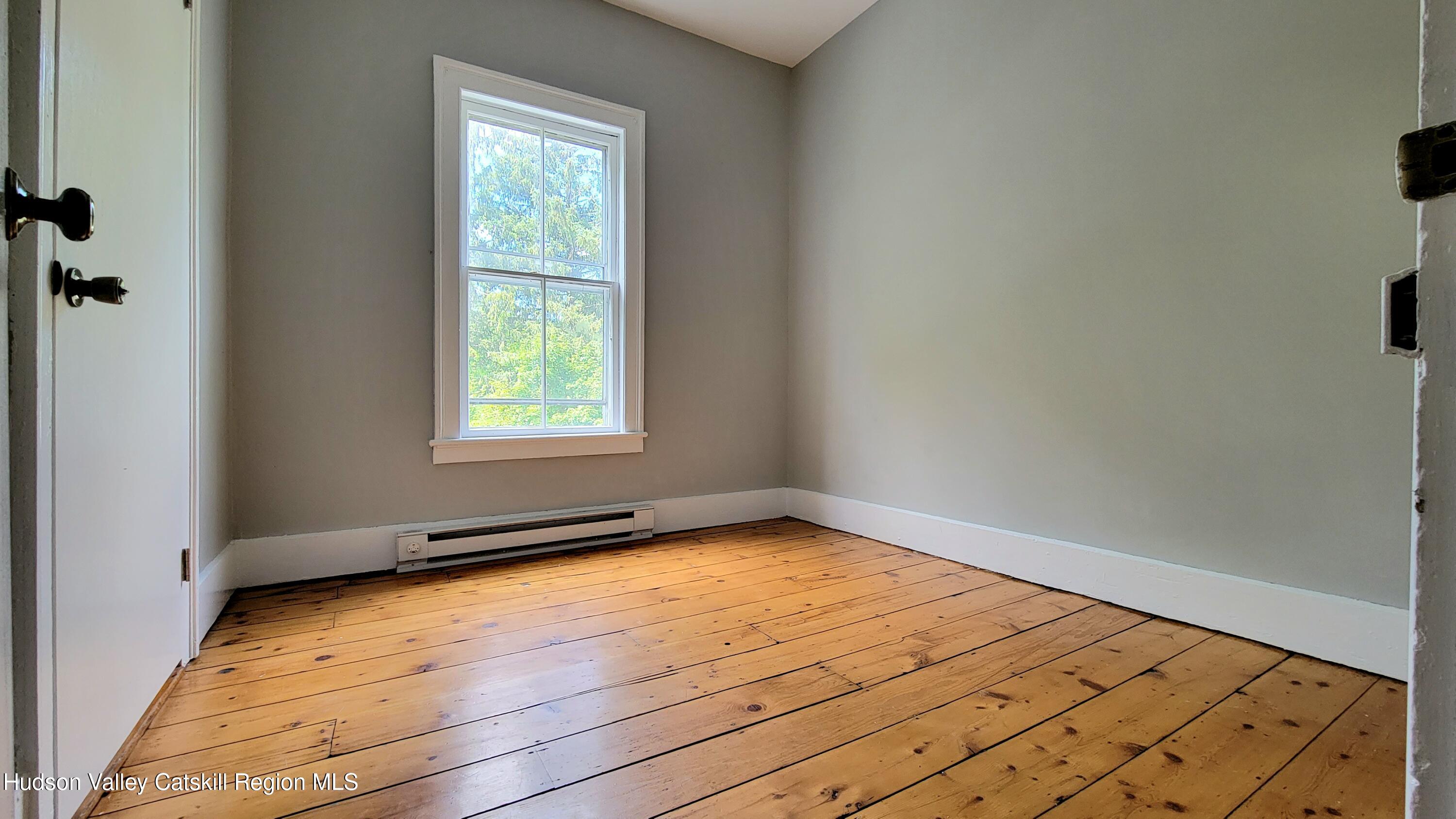 22 Spring Street Chatham, NY 12037 - Photo 55 of 61 an empty room with wooden floor and windows