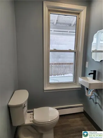 a bathroom with a toilet a sink and a window