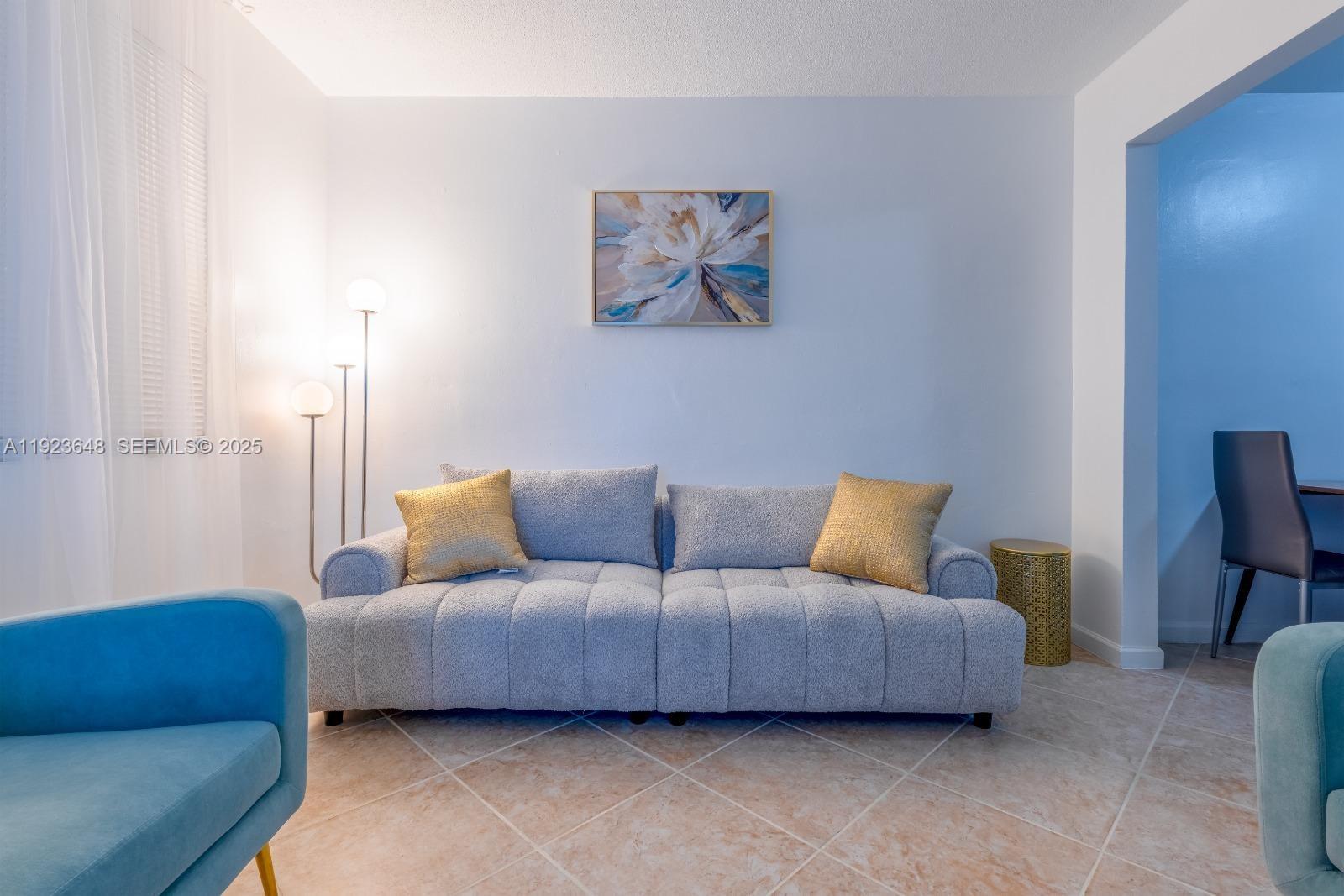 828 Southwest 2nd Street, Unit 2 Miami, FL 33130 - Photo 5 of 5 a living room with furniture a couch and a lamp on the dresser