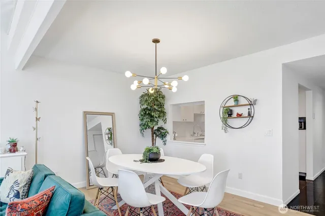a dining room with furniture potted plants and wooden floor