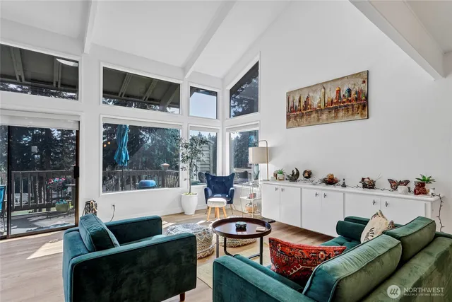 a living room with furniture a flat screen tv and a floor to ceiling window