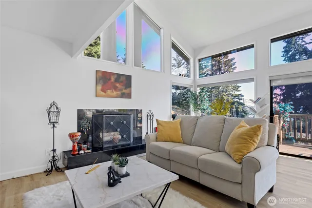 a living room with furniture a fireplace and a large window