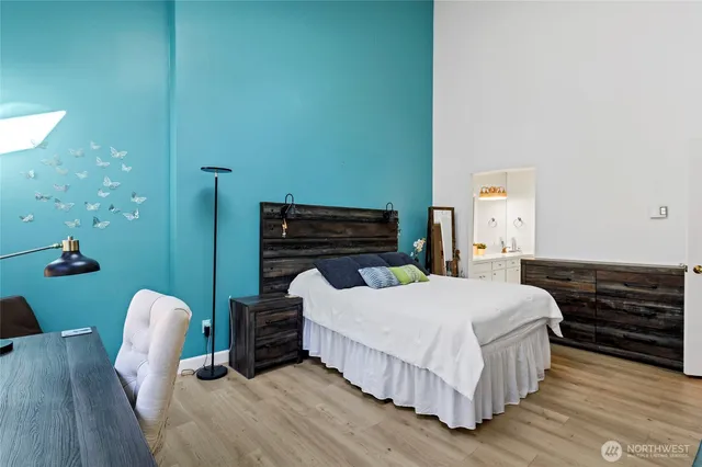 a bedroom with a bed and wooden floor