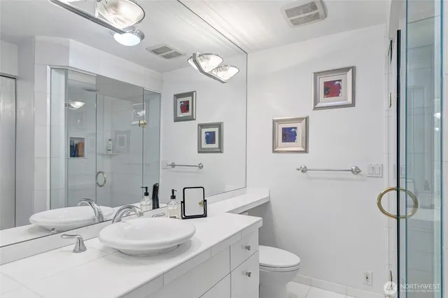 a bathroom with a granite countertop sink mirror vanity and toilet