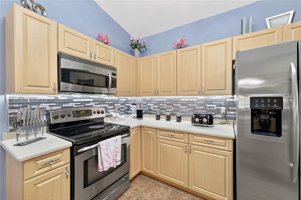 5336 Edgewater Way Oxford, FL 34484 - Photo 36 of 45 a kitchen with granite countertop a stove sink and microwave